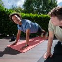 Twee mannen in hoge plank naast elkaar