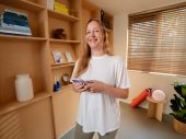 Lachende vrouw met telefoon in hand in yogastudio
