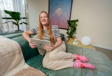 Blonde vrouw op bank met tablet