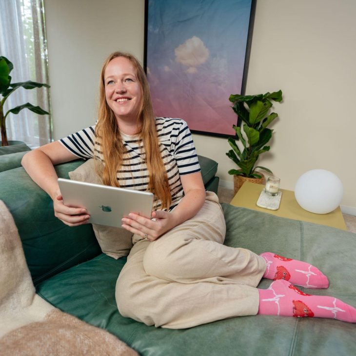 Blonde vrouw op bank met tablet