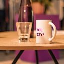 Glas en mok staan naast elkaar op een licht, houten tafeltje