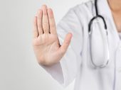 Persoon in wit uniform met stethoscoop steekt platte hand op