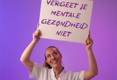Vrouwelijke zorgmedewerker in wit uniform houdt bord omhoog met tekst 'Vergeet je mentale gezondheid niet' tegen paarse achtergrond