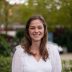 Foto van vrouw met lang bruin haar in witte blouse in natuurlijke omgeving