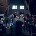 Een filmzaal of bioscoop met tribune waarop verschillende mensen zitten, zowel mannen als vrouwen wachtend tot de film begint.