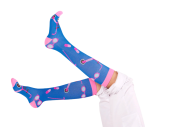 Twee benen in de lucht met donkerblauwe met roze zorgsokken aan, compressiesokken.