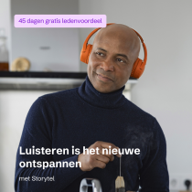 Een man met oranje koptelefoon heeft een theezakje vast.