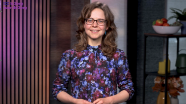 Portret foto van Anneke valk, met bruin krullend haar en brildragend