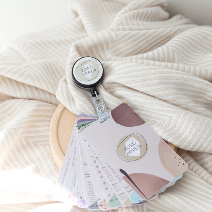 Een zorgzipper ligt opengeklapt op een bed. Een uittrekbaar notitieboekje met aantekeningen.