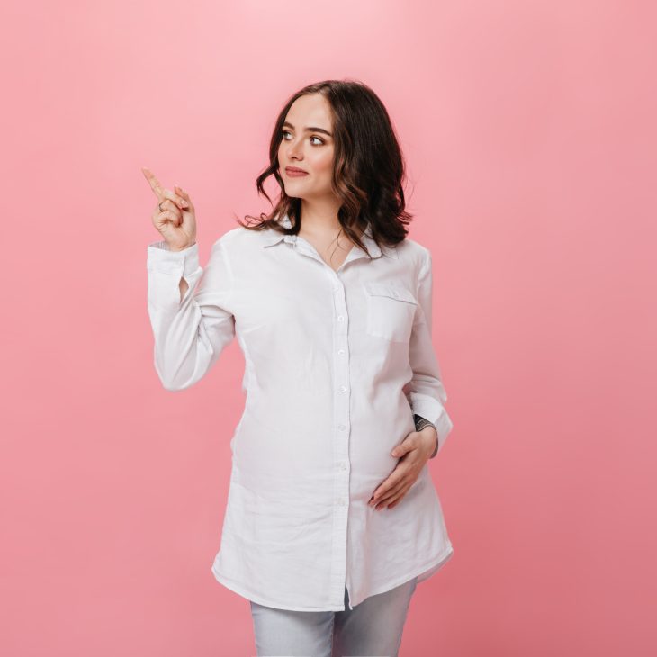 zwangere vrouw met donker haar en witte blouse