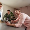 3 zorgmedewerkers kijken naar tablet