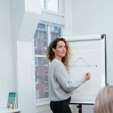 Vrouw met lang krullend haar voor een flipover met een grafiek