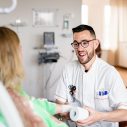 mannelijke zorgmedewerker met bril heeft een rol verband beet