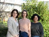 Drie vrouwen staan naast elkaar in natuurlijke omgeving buiten