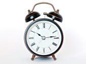 Zwarte wekker met witte wijzerplaat met Romeinse cijfers