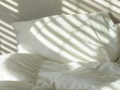 Wit beddengoed met reflectie van lamellen