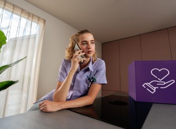 Bellende vrouw in paarse verpleegkundige outfit met paars blok met witte illustratie van hand met hart