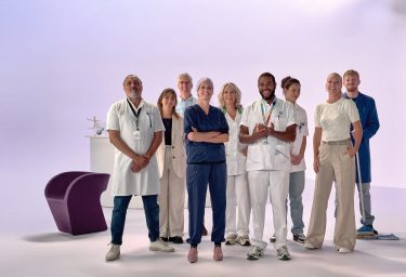 Groep van 9 zorgmedewerkers in witte en blauwe kleding