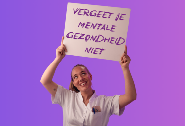 Jonge vrouwelijke zorgmedewerker in witte jas houdt bord omhoog met tekst: Vergeet je mentale gezondheid niet