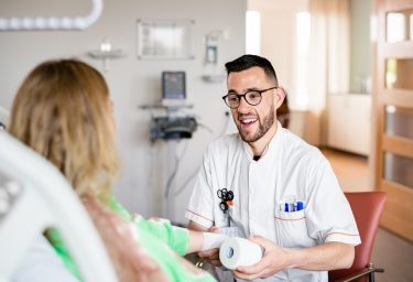 mannelijke zorgmedewerker met bril heeft een rol verband beet