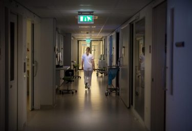 Zorgmedewerker loopt door ziekenhuisgang