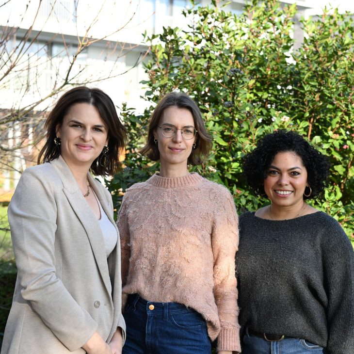 Drie vrouwen staan naast elkaar in natuurlijke omgeving buiten