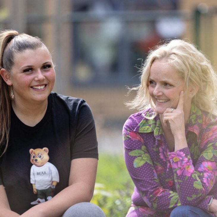 twee lachende vrouwen, een draagt een zwart tshirt met een beer