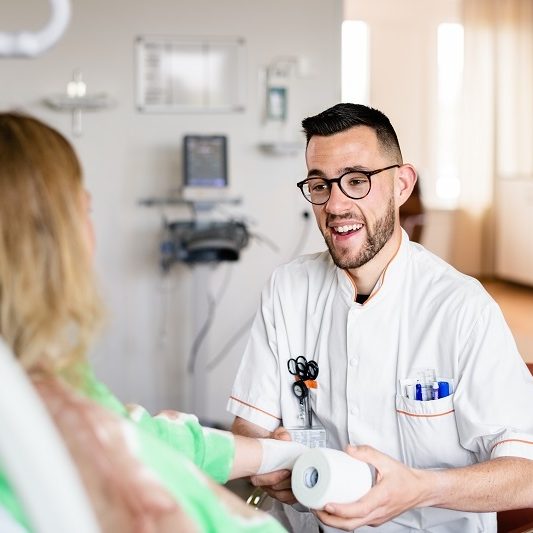 mannelijke zorgmedewerker met bril heeft een rol verband beet