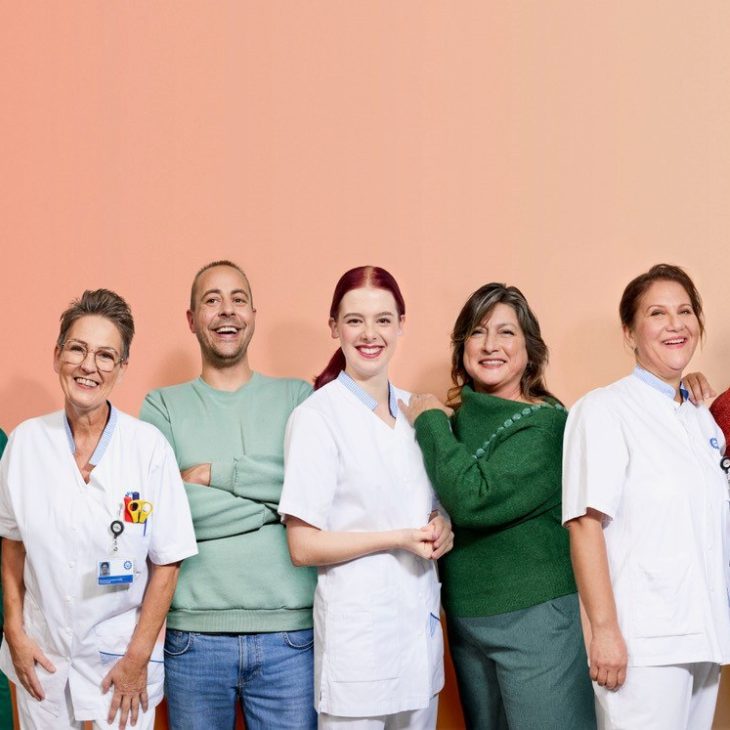 Groep van 7 zorgmedewerkers voor oranje achtergrond