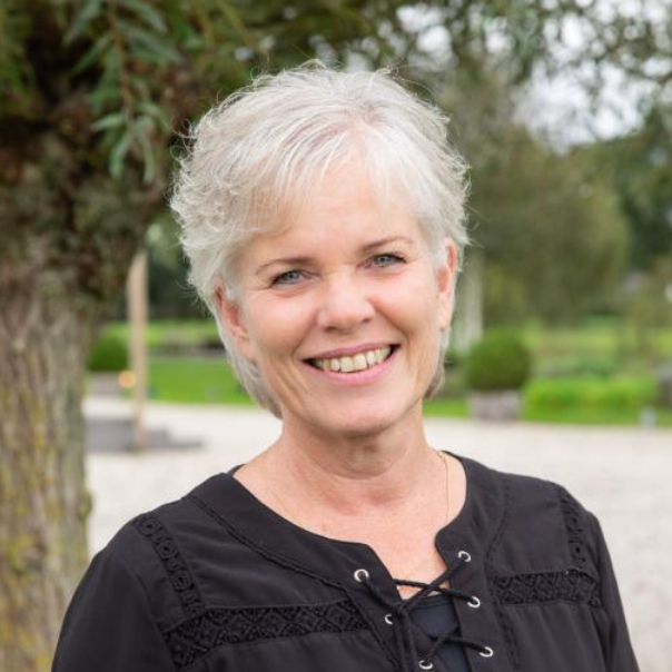 Portret van Marga Vrijmoeth, lachende vrouw met kort grijs haar en zwart shirt