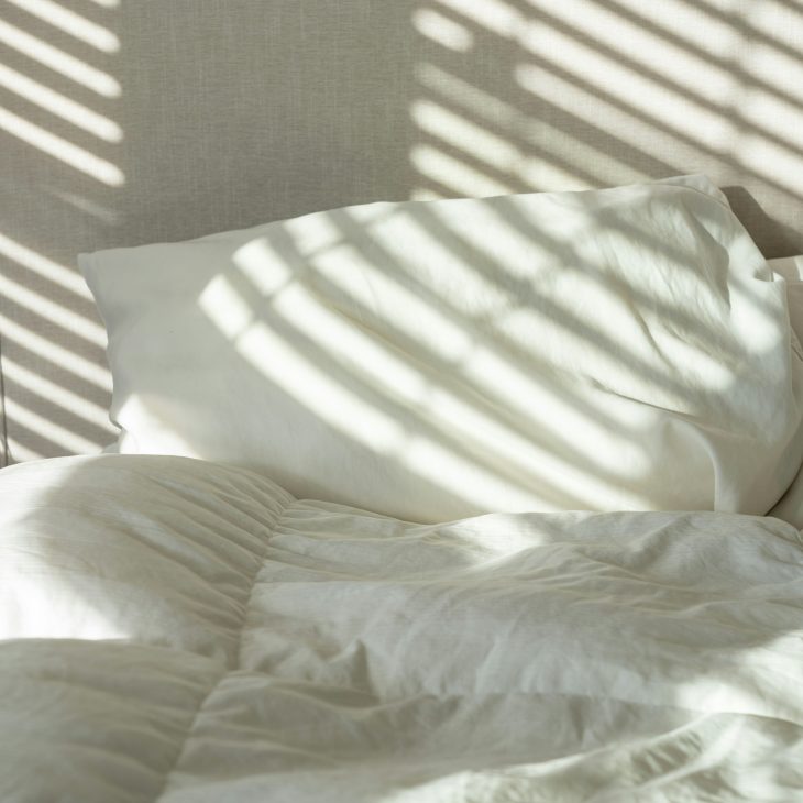 Wit beddengoed met reflectie van lamellen