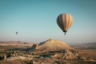 luchtballon voor een berglandschap. op de achtergrond nog een luchtballon