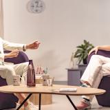 Twee generaties zitten in stoelen in gesprek met elkaar